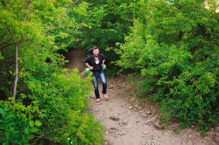 Traveler man walking with backpack in rocky mountains. Travel concept