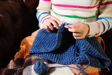 Close-up of woman hands knitting colorful wool yarn.