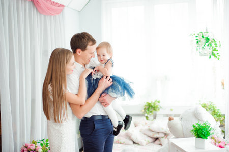 Lovely family smiling and laughing, posing at camera, and hugging each other for family photo.の写真素材