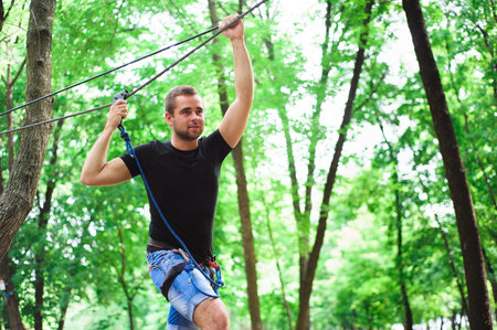 Hiking in the rope park beautiful sports guyの写真素材