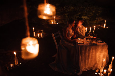 Romantic dinner of a young couple by candlelight in the mountainsの写真素材
