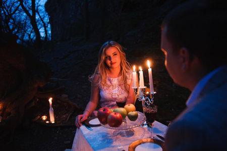 Romantic couple together over candlelight during romantic dinner outdoorsの写真素材