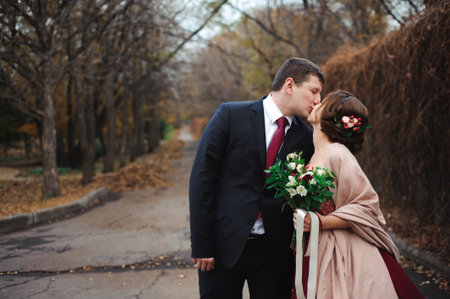 Bride and groom hugging in a forest in the autumn forest, wedding walkの写真素材