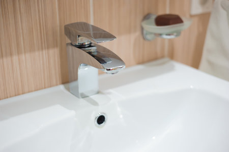 Woman doing chores in bathroom, cleaning tap.の写真素材