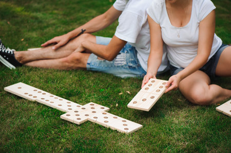 Young man and woman playing giant dominoes in the Park on the grassの写真素材