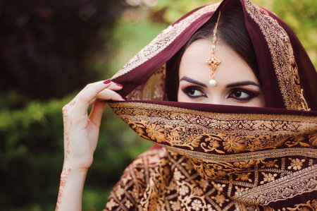 Portrait of beautiful indian girl . Young hindu woman model with tatoo mehndi and kundan jewelry