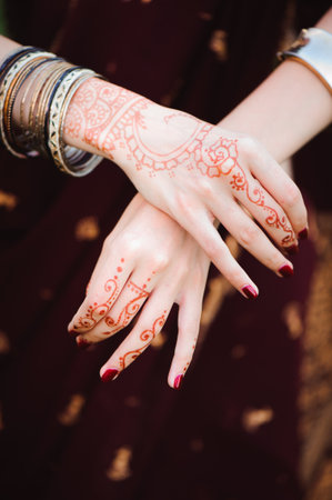 Mehndi tattoo. Woman Hands with black henna tattoos. India national traditions.