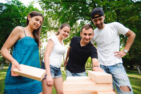 Friends playing board game outdoors. Outdoor games friends playing in a park.の写真素材