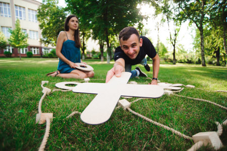 Friends playing tic-tac-toe on green grass in the parkの写真素材