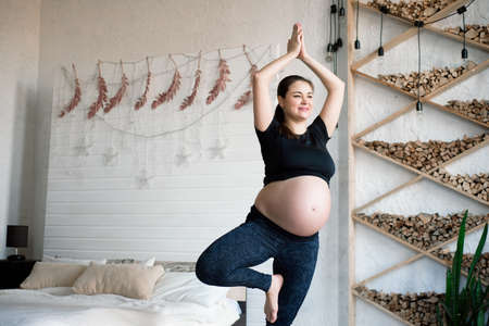Pregnant woman during training yoga and sport at home.