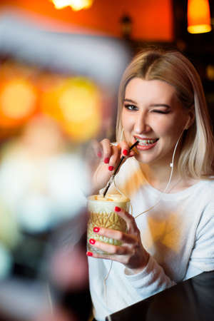Beautiful woman drinking coffee at the cafe wintertime.の写真素材