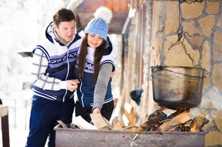 Family in love laughing and cooking in the winter outdoors. Bonfire, barbecue, bowler.の写真素材
