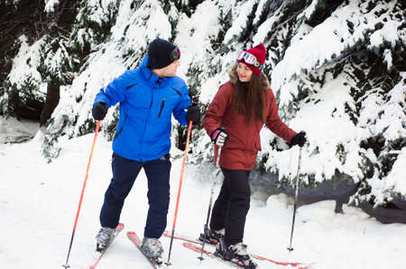 happy married couple skiing at a ski resort in the forestの写真素材