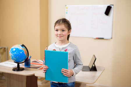 Portrait of diligent girl looking at camera in the classroom.の写真素材