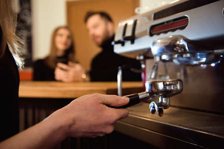 Female starting her day on a new job as a barista. Working in a cafe.の写真素材
