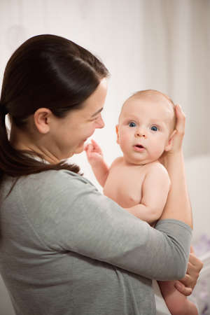 Young mother hugging her newborn child. Love, trust and tenderness concept. Bedding and textile for...