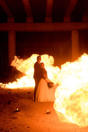 Halloween couple standing with flamethrower. big fireの写真素材