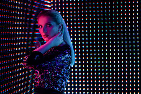 Fashion young elegant woman. Colored neon background, studio shot.の写真素材