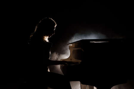 Pianist musician piano music playing. Musical instrument grand piano with woman performerの写真素材