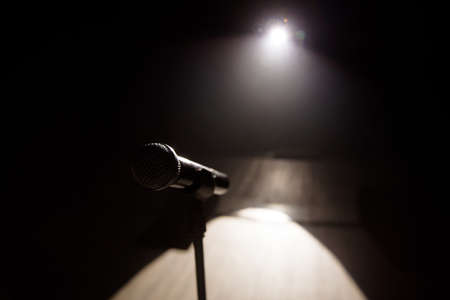 Close up of microphone on stage in black backgroundの写真素材