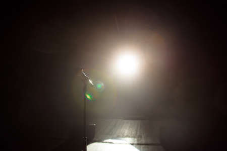 Close up of microphone on stage in black backgroundの写真素材