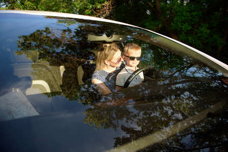 Unsafe driving. A small child sits in her mother s arms in the drivers seatの写真素材