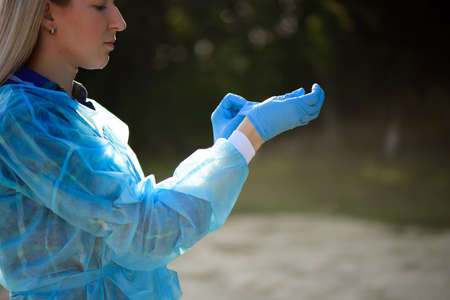 Girl puts on rubber gloves before garbage collection.