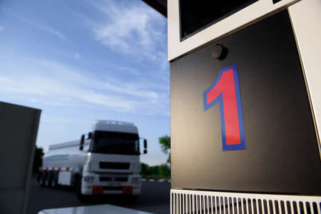 Large metal fuel tank truck transporting fuel at a gas station.の写真素材