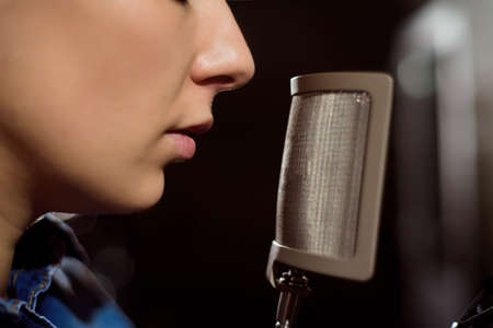 Close up of a singer recording a track in a studioの写真素材