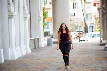 Pretty young woman walking on the city street. Casual fashion, plus size model. xxl women on nature.の写真素材