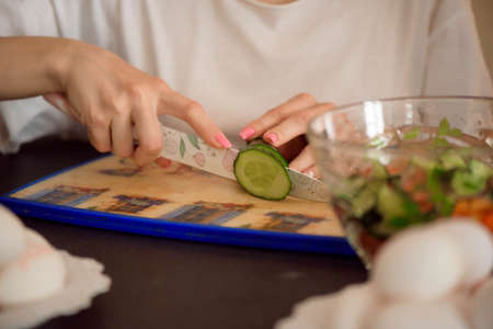 Young girlfriends chopping vegetables with twin in a family home kitchen.の写真素材