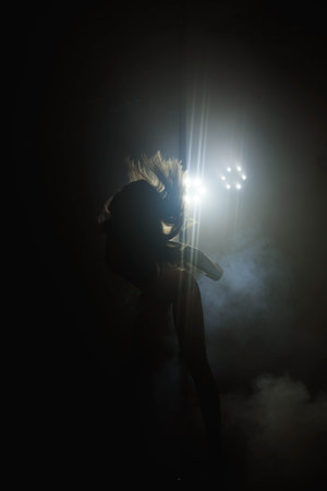 Pretty woman dancing in a pole dance studioの写真素材