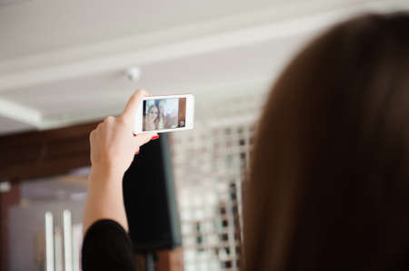 Three young girls are doing selfie photo in a restaurant.の写真素材
