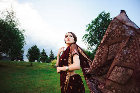 Portrait smiling of beautiful indian girl. Young woman model with red jewelry set .の写真素材