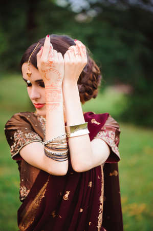 Portrait smiling of beautiful indian girl. Young woman model with red jewelry set .の写真素材