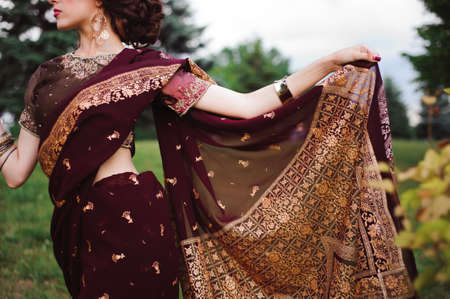 Indian girl with oriental jewellery and make-up henna applied to hand. Brunette Hindu model girl with Indian jewels.の写真素材