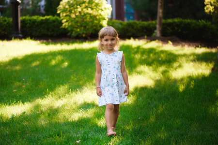 Sweet little girl outdoors with curly hair in the wind.の写真素材