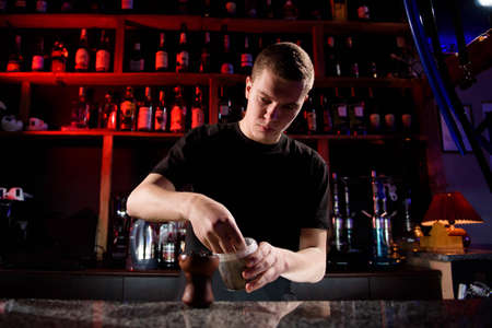 Barman fills black burnt ceramic bowl for hookah smoking different types of tobacco.の写真素材