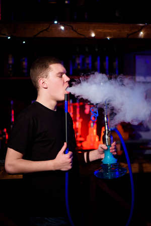 Man makes hookah. Modern hookah with coconut charcoal for relax and shisha smoke.の写真素材