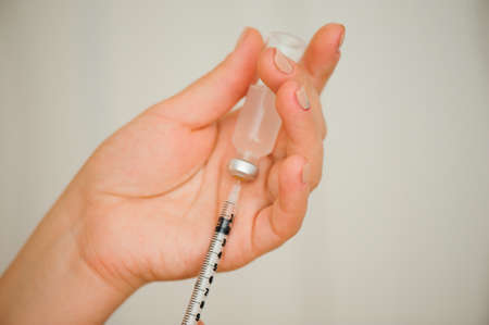 A girl fills a syringe for insulin injections. Diabetes. The short-acting insulin. Insulin injection at homeの写真素材