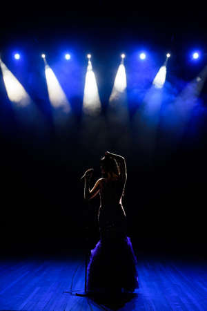Singing woman silhouette with smoke background on the stage.の写真素材