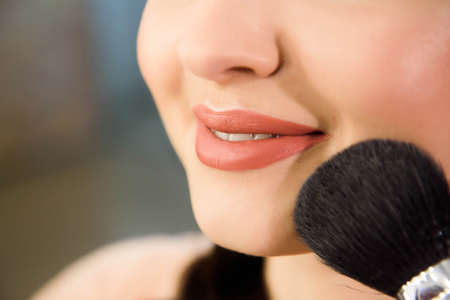 Beauty and health clean Skin of young female Model. Woman applying Powder Foundation with Brush.の写真素材