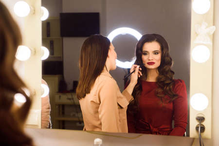 Make up artist doing professional make up of young woman. School of make-up artists.の写真素材