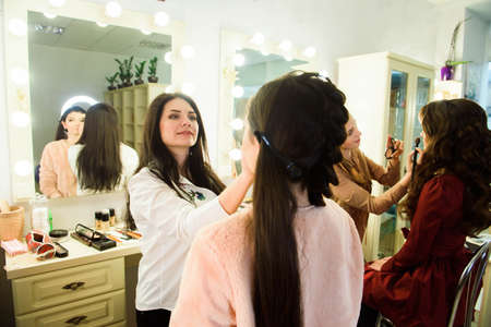 Make up artist doing professional make up of young woman. School of make-up artists.