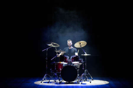 Drummer playing the drums with smoke and powder in the background.の写真素材