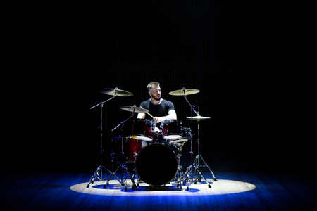 Drummer playing the drums with smoke and powder in the background.