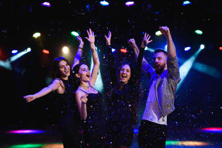 Four friends making having fun among confetti.の写真素材