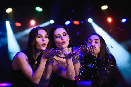 Four friends making having fun among confetti.