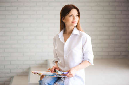 Concept Artist Beautiful girl. Beautiful women are creating art. Young artist painting in the houseの写真素材