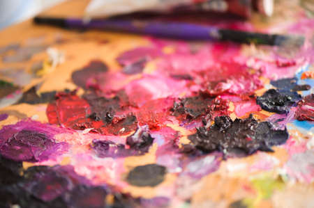 art, creativity and people concept - close up of artist with palette knife painting still life on...